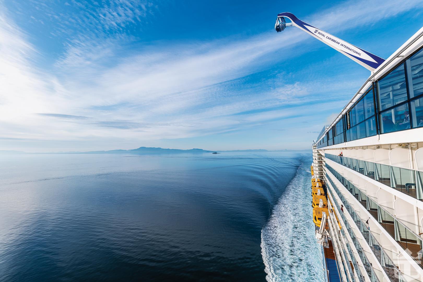 Side view of Ovation of the Seas with wide scenic of Alaska seascape - Photo Credit: Jason Lisiewski